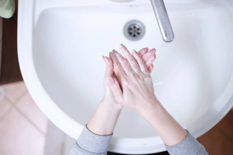 洗面所で石鹸を泡立てて手を洗う女性